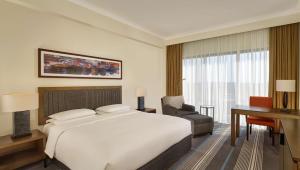 a bedroom with a large white bed and a desk and a desk at Hyatt Regency Birmingham in Birmingham
