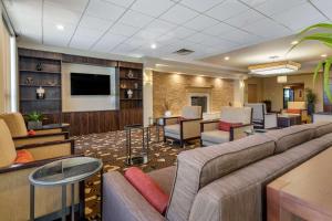 a lobby with a couch and chairs and a tv at Comfort Inn Glenmont - Albany South in Glenmont