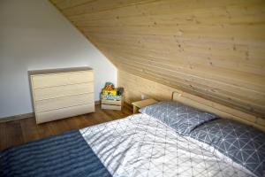 ein Schlafzimmer mit einem Bett und einer Holzwand in der Unterkunft Domek w Klisiówkach in Ujsoły