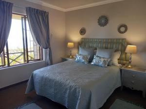 a bedroom with a bed with blue pillows at 110 Bay View in Brenton-on-Sea