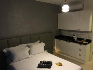 Loft em prédio sofisticado في ريو دي جانيرو: غرفة نوم بسرير أبيض ومطبخ +40 صورة