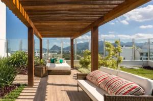 Loft em prédio sofisticado في ريو دي جانيرو: فناء على أريكة وكراسي على السطح