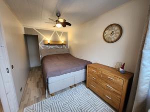 um pequeno quarto com uma cama e um relógio na parede em Kuuse 4 Apartment em Haapsalu