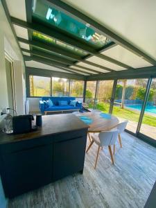 Magnifique maison avec piscine في لو بورت - دي - بارك: مطبخ وغرفة معيشة مع طاولة وكراسي