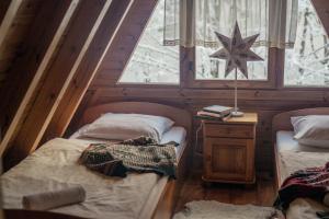Domek Poniwiec Mała Czantoria في أوسترون: سريرين توأم في غرفة مع نافذة
