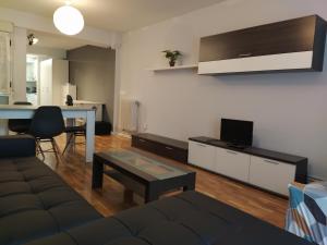 a living room with a couch and a tv on a wall at Apartamento Jarauta 50 in Pamplona