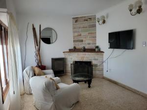 a living room with two chairs and a fireplace at Casa frente al mar Monte Hermoso in Monte Hermoso