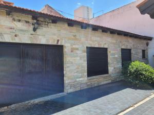 un edificio de ladrillo con dos puertas de garaje. en Casa frente al mar Monte Hermoso en Monte Hermoso