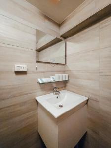 a bathroom with a white sink and a mirror at Taipei Inn in Taipei