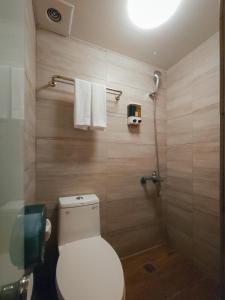 a bathroom with a toilet and a shower with towels at Taipei Inn in Taipei