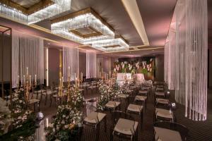 um salão de banquetes com mesas, cadeiras e flores em EPIC SANA Marquês Hotel em Lisboa