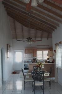 a kitchen with a table and chairs and a ceiling fan at Villa Benito in Nevis
