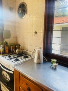 eine Küchentheke mit einem Herd und einem Wasserkocher in der Unterkunft Cruz del Sur in Pinamar