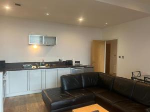 a living room with a couch and a kitchen at Modern 2BD2Bath Apart CityCentre in Glasgow