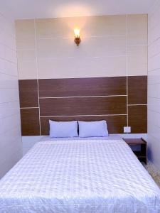 1 dormitorio con 1 cama grande y cabecero de madera en Khách sạn Ngọc Bích 2 en Thôn Tân Hội