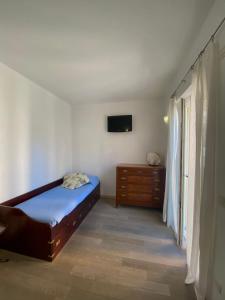 a bedroom with a bed and a dresser and a television at Clelia Apartments - Deiva Marina in Deiva Marina
