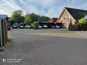 un parking avec des voitures garées devant un bâtiment dans l'établissement Ferienhaus Haus Middelsfähr, à Dangast