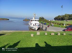 un grand bateau blanc amarré dans un corps d'eau dans l'établissement Ferienhaus Haus Middelsfähr, à Dangast 25 autres photos