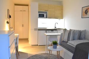 un piccolo soggiorno con divano e cucina di Seifert Residence a Praga