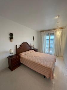 a bedroom with a large bed and a window at APCOSTAS Cala Gonzalez in Alcossebre