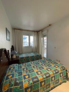 a bedroom with two beds and a window at APCOSTAS Cala Gonzalez in Alcossebre