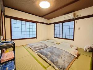 een kamer met 2 bedden en 2 ramen bij KIKI HOUSE in Tokyo