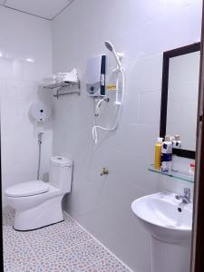 La salle de bains blanche est pourvue de toilettes et d'un lavabo. dans l'établissement Khách sạn Ngọc Bích 2, à Thôn Tân Hội