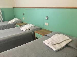 a room with two beds and two tables with towels at Bella Italia Sport Village in Lignano Sabbiadoro