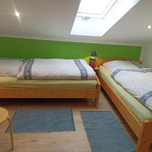 two beds in a room with green walls at Ferienhof Schrädobler in Kößlarn