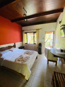 a bedroom with a large bed with a red wall at Hotel Casa Alpina in Núcleo Mauá +66 photos