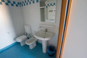 a small bathroom with a sink and a toilet at Bella Italia Sport Village in Lignano Sabbiadoro