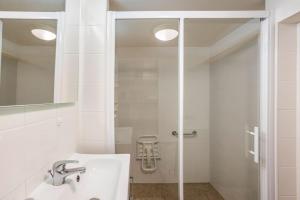 een witte badkamer met een douche en een wastafel bij Maison atypique dans circulade in Bram