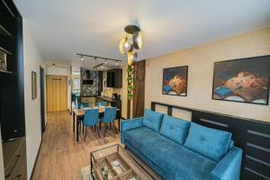 uma sala de estar com um sofá azul e uma sala de jantar em Apartament Kilińskiego 17a,2 em Szklarska Poręba
