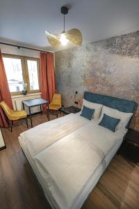 um quarto com uma grande cama branca e uma mesa em Apartament Kilińskiego 17a,2 em Szklarska Poręba