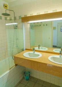 a bathroom with two sinks and a shower at Appartement 91 Palais des Gouverneurs in Saint-Martin-de-Ré