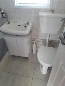 ein weißes Bad mit einem WC und einem Waschbecken in der Unterkunft 17 Breakaway Chalet in Great Yarmouth