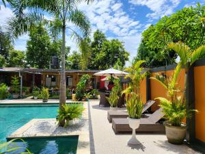 a resort with a swimming pool and palm trees at Dewi Sri Guesthouse in Mataram