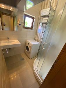 a bathroom with a shower and a washing machine at Grand Apartments-For Groups in Sarajevo +33 photos