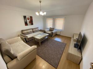 a living room with a couch and a table at Grand Apartments-For Groups in Sarajevo