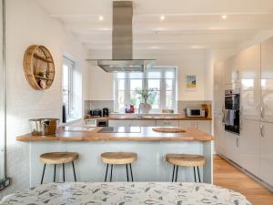 a kitchen with a counter and stools in it at Schaels Retreat in Binham