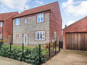 a brick house with a wooden garage at Schaels Retreat in Binham