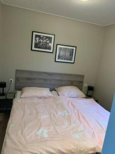 een bed in een slaapkamer met twee foto's aan de muur bij Luxus Chalet Waterfront in Lathum