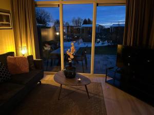 a living room with a couch and a table and a television at Luxus Chalet Waterfront in Lathum