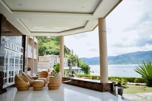 balcón con sillas y vistas al agua en Portola Grand Renggali Hotel Takengon en Takengon
