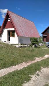un granero rojo y blanco con techo rojo en mali raj, en Žabljak