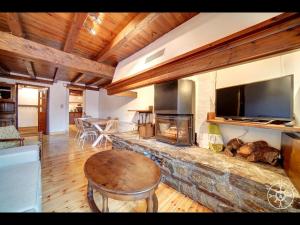 a living room with a stone fireplace with a tv at Casa Pins de Alma de Nieve in Baqueira-Beret