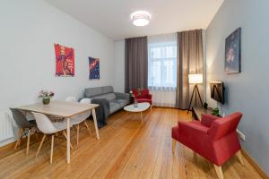 - un salon avec un canapé, une table et des chaises dans l'établissement Bearsleys Archers Apartments, à Riga