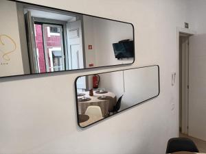 a mirror on a wall with a table in a room at Walk'in Sodré in Lisbon