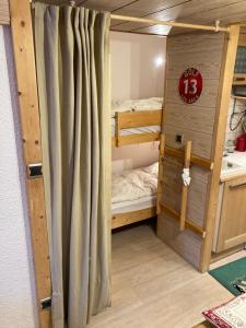 Cette chambre comprend 2 lits superposés et un rideau. dans l'établissement Le 104 Miravidi, à Bourg-Saint-Maurice