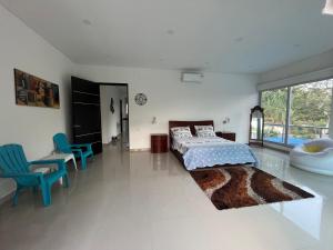 1 dormitorio con 1 cama, escritorio y sillas en Casa Campestre en Condominio Lagos Del Peñon, en Girardot